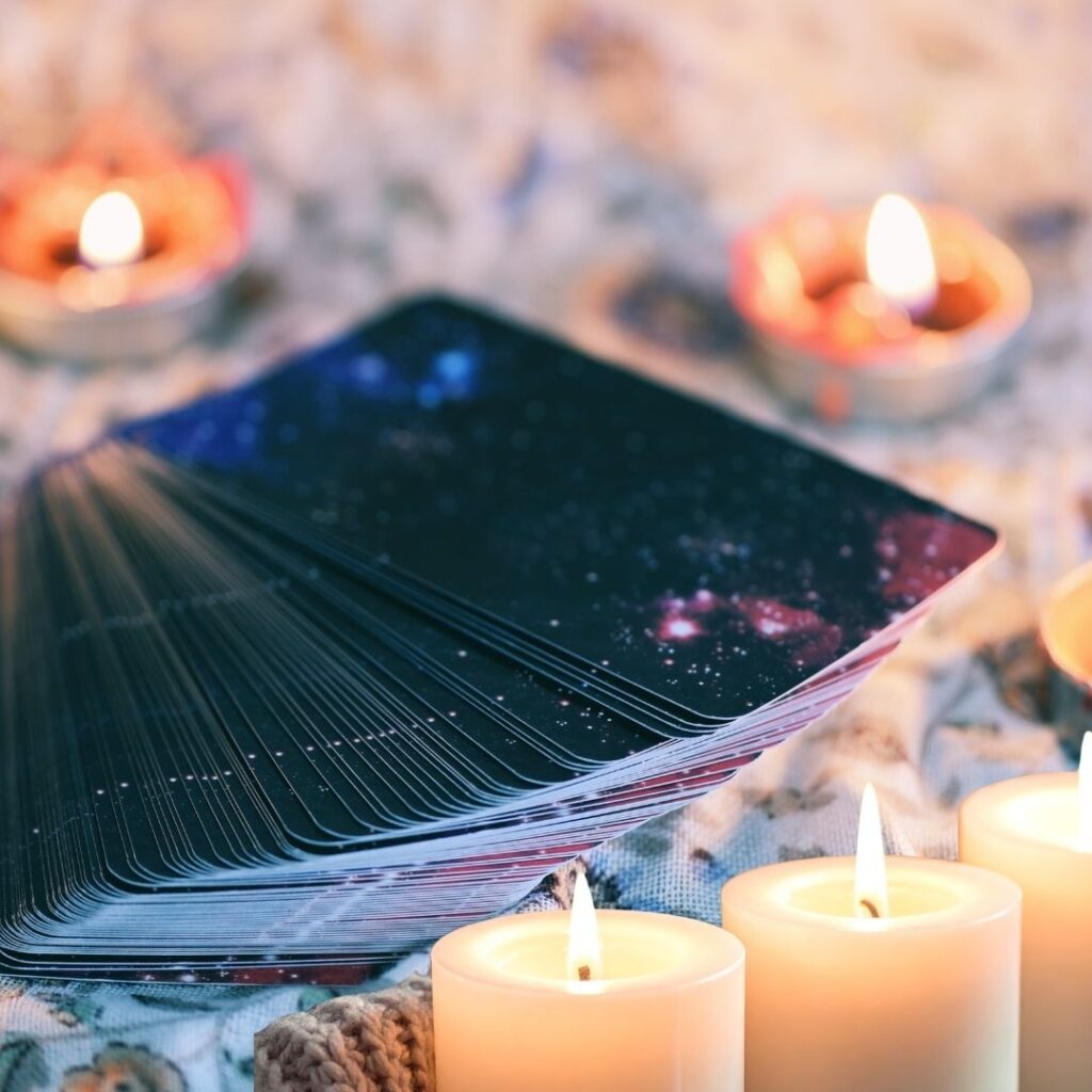 Baraja espiritual con cartas cósmicas y velas para lectura energética